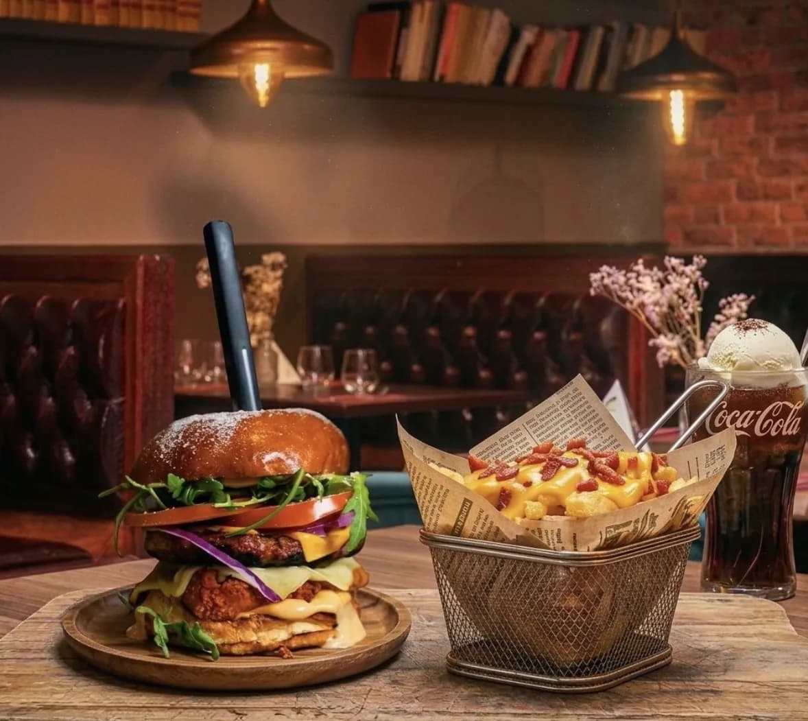 Burger Manhattan, frites bacon cheddar et Coca-Cola servis dans la salle du Manhattan Grill.